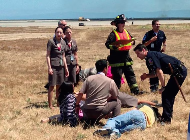 Image: File picture shows Asiana Airlines flight attendant Kim Ji-yeon standing near a runway with rescued passengers in San Francisco